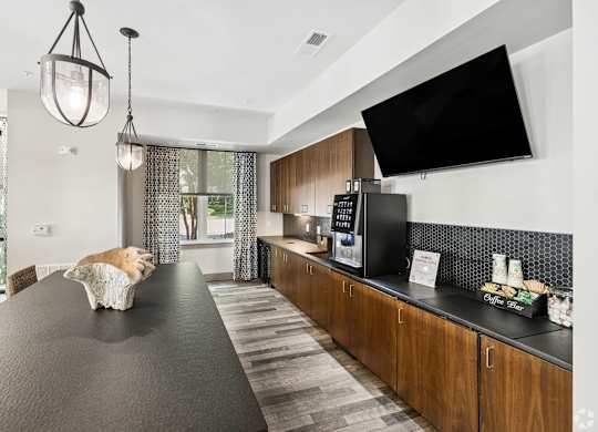 A dog is sitting on a table in a modern kitchen.