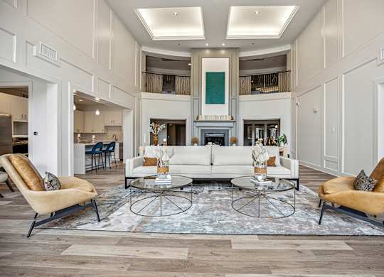 A living room with a white sofa and two chairs.