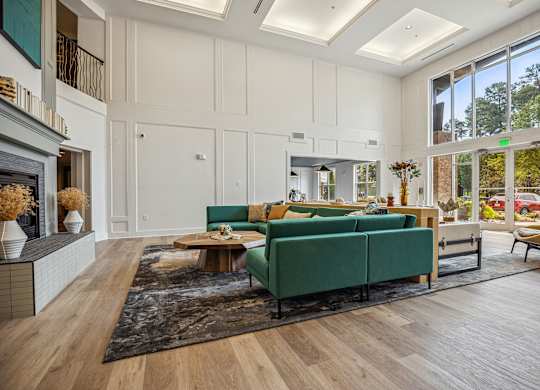 A living room with a green couch and a fireplace.