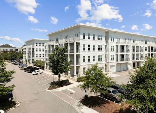 A large white building with a parking lot in front.
