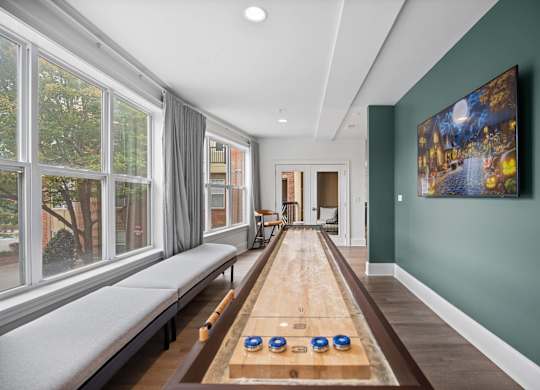 A room with a long table and a painting on the wall.