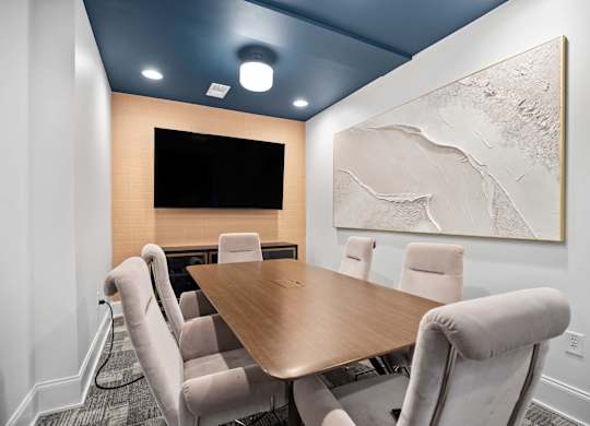 A conference room with a large table and chairs.