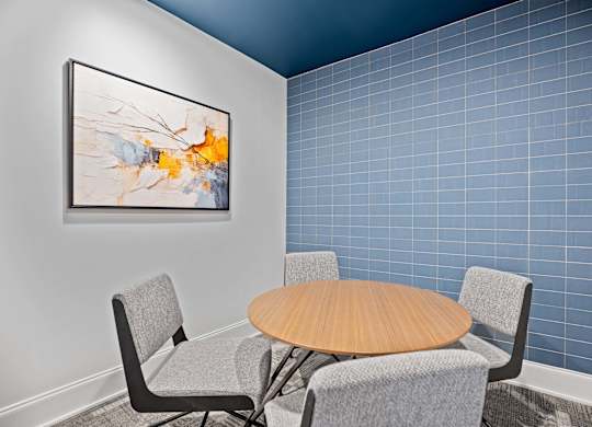 A modern dining room with a round table and grey chairs.