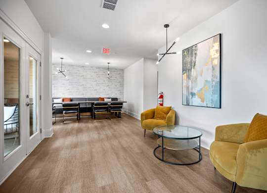 A living room with a glass table and yellow chairs.