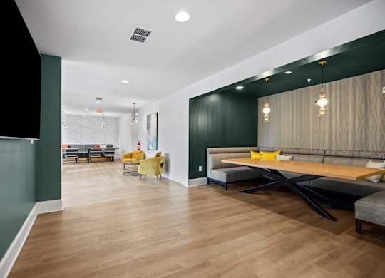 A modern living room with a long wooden table and yellow chairs.
