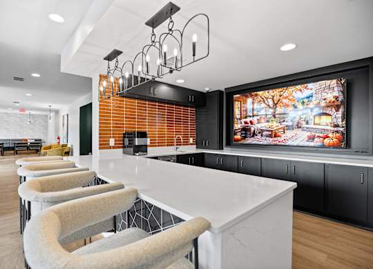 A modern kitchen with a long white island and bar stools.