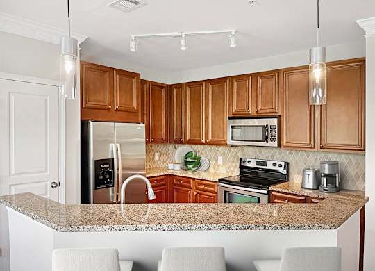 A kitchen with wooden cabinets and granite countertops.