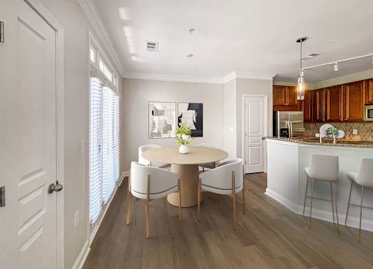 A dining room with a round table and chairs.