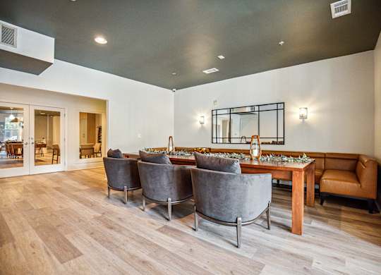 A modern dining room with a long table and grey chairs.