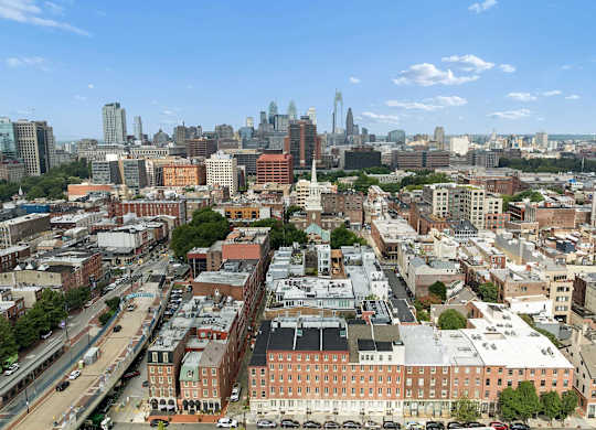 A cityscape with a mix of modern and older buildings, with a clear blue sky above.