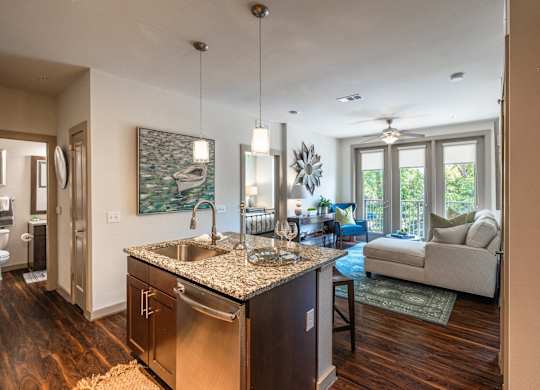 A kitchen with a granite countertop and stainless steel appliances.