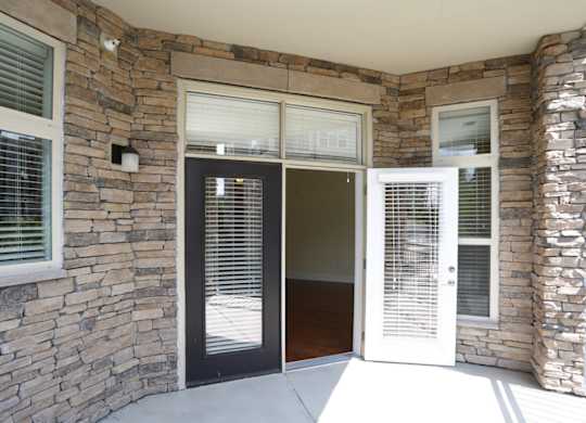 A stone wall with a black door and a white door.