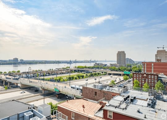 A cityscape with a river and a bridge in the background.