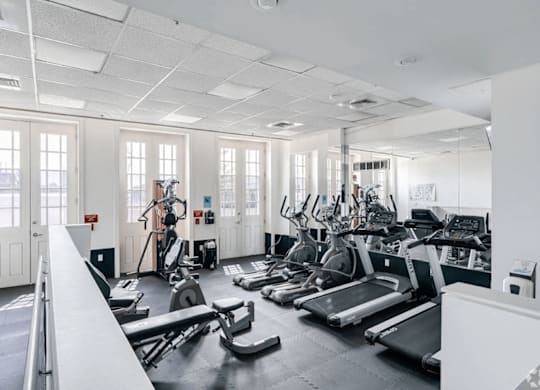 A gym with treadmills, exercise bikes, and other equipment.
