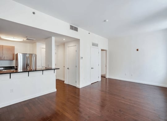 A spacious room with wooden floors and white walls.