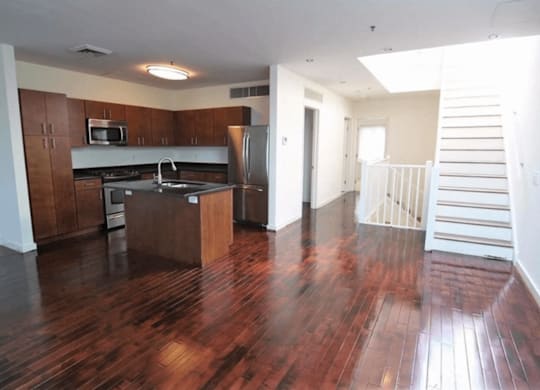 A kitchen with wooden floors and a refrigerator.