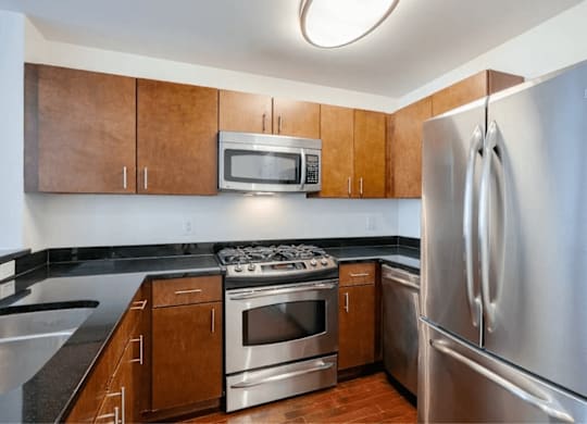 A kitchen with a stove, oven, microwave, and refrigerator.