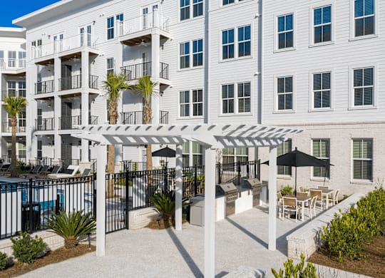 A white building with a pool and patio area.