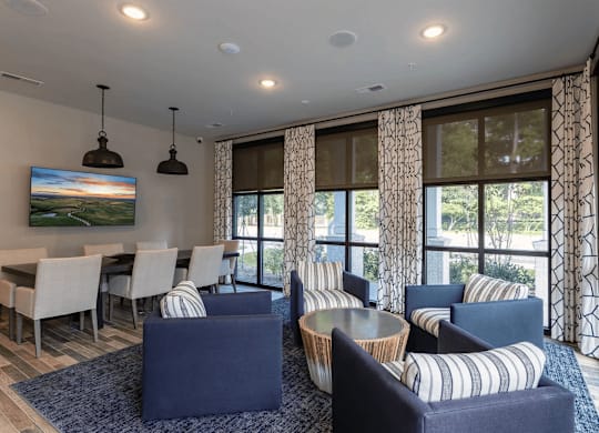 A living room with a large painting on the wall and a dining table with chairs.