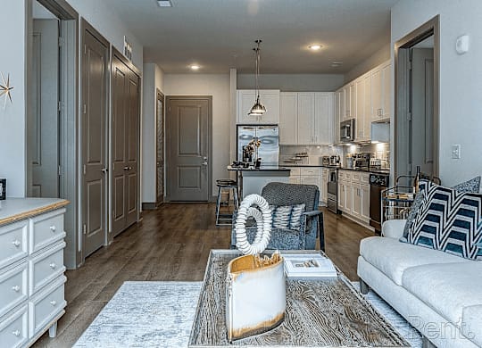 A modern kitchen with a white couch and a wooden floor.