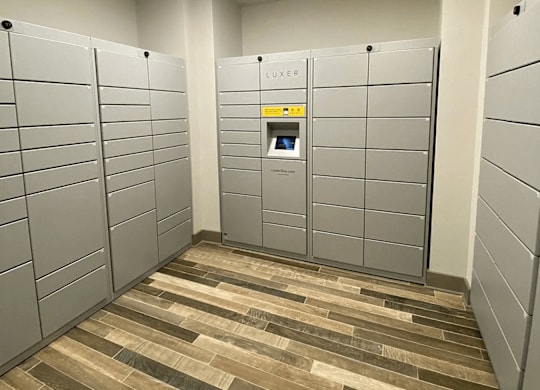 A room with a wood floor and a wall of lockers.