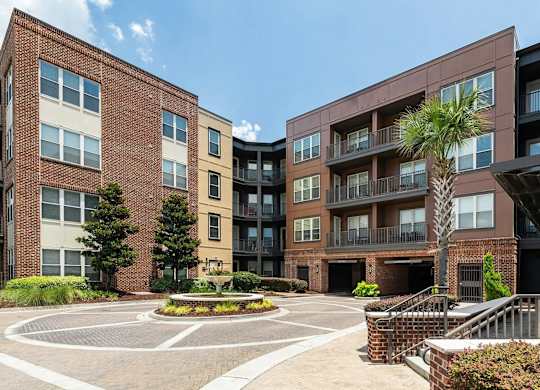 A large brick building with a courtyard in front.