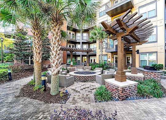 A courtyard with a fire pit and a tree.