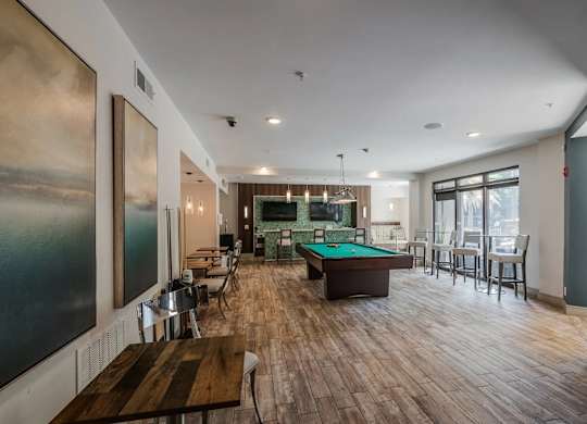 A room with a pool table and a painting on the wall.