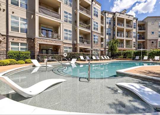 A swimming pool in front of apartment buildings.
