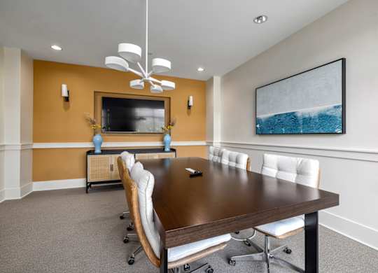 A conference room with a long table and chairs.