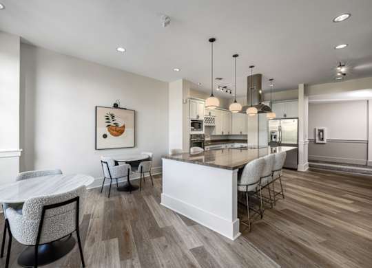 A modern kitchen with a dining table and chairs.