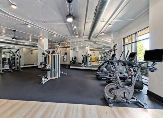 A spacious gym with a variety of equipment including treadmills, weights, and exercise machines.