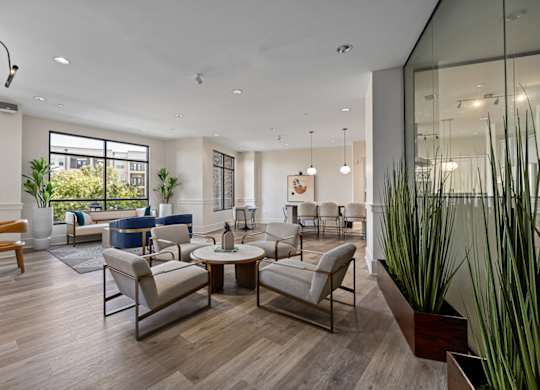 A modern living room with a glass wall and a wooden floor.