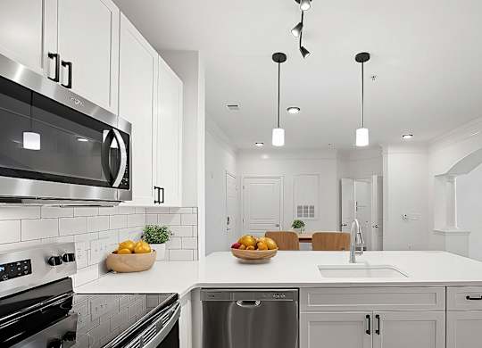 A modern kitchen with a stainless steel oven and a white countertop.