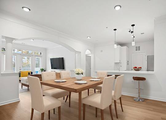 A dining room with a wooden table and chairs.