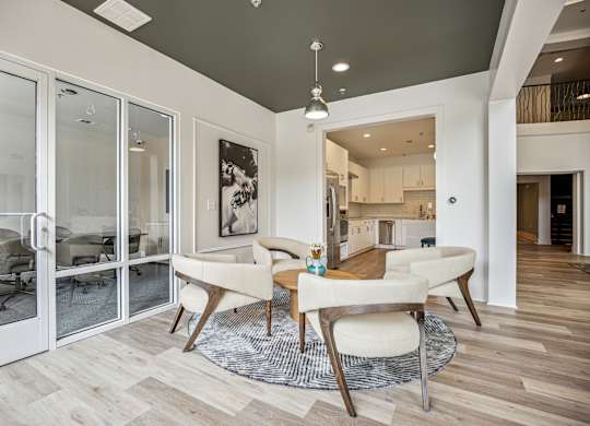 A modern dining room with a glass door leading to a kitchen.