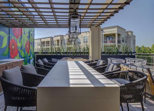 A patio with a table and chairs under a roof.