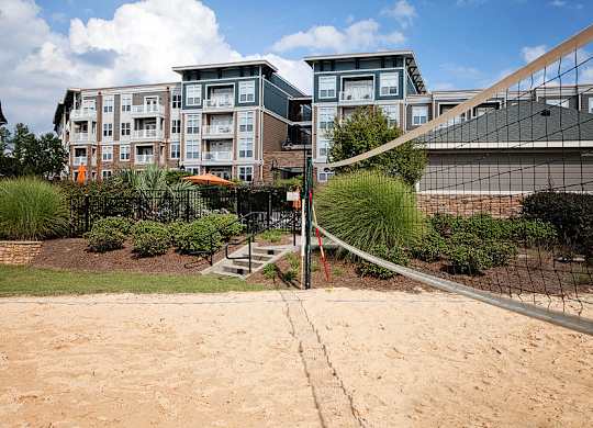 A volleyball net is set up on a sandy court.