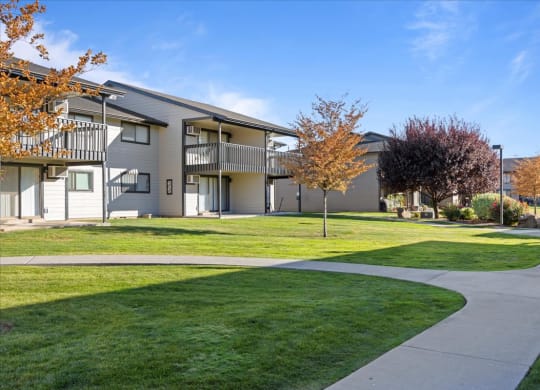 Exterior apartments with balconies and sidewalks through the bright green grass and well-maintained landscaping. at Brix, Walla Walla, WA, 99362