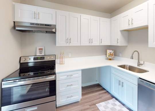 Renovated kitchen at Peak 88 Apartments Renton WA with bright white cabinets, stainless appliances, and ample counter space.