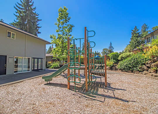 A playground with a green slide and a red and green climbing frame.