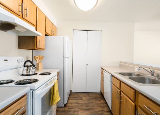 The galley-style kitchen has white appliances, a stainless steel sink, and an accordion door pantry on the back wall.at Clearwater, Idaho