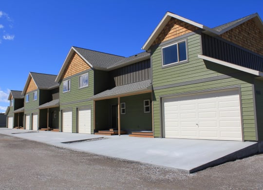 a row of green houses with white garage doorsat Copper Pines, Bozeman, 59718