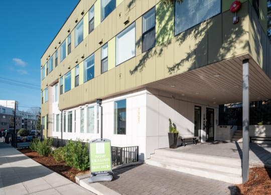 the front of a building with stairs and a green sign in front at Enve, Seattle, 98102