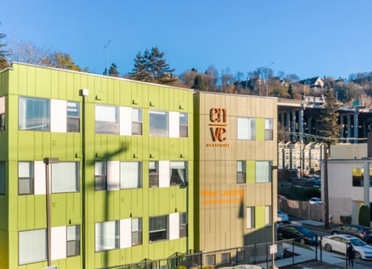 a green and yellow building with trees in the background at Enve, Seattle Washington