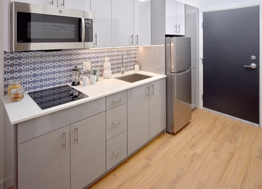 a kitchen with white cabinets and a sink and a refrigerator at Enve, Seattle