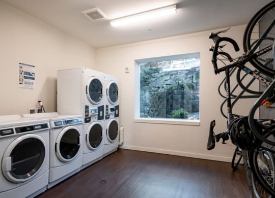 a laundry room with washing machines and bicycles on the wall at Enve, Seattle, 98102