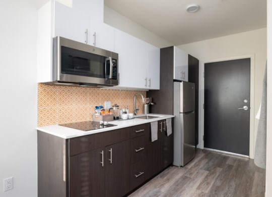 a kitchen with a sink and a microwave and a refrigerator