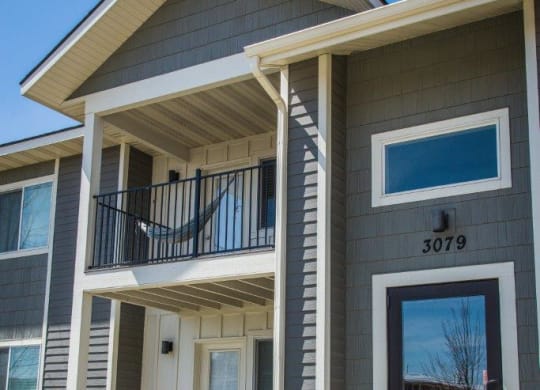 a gray house with a front porch and a glass door at Madison Park, Montana, 59718