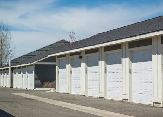 a row of white garages with white doors